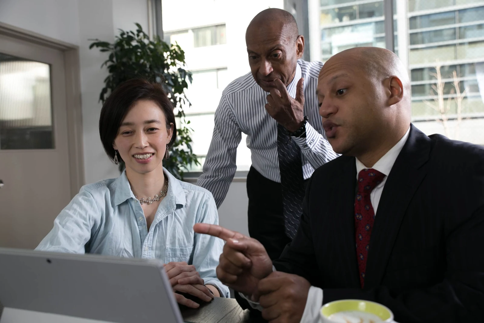A group gathered around a laptop at Ginza Hub